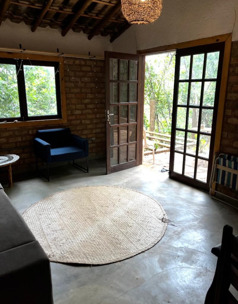 Sala com móveis de casa em meio à natureza no Bosque do Lapão em Lençois na Chapada Diamantina