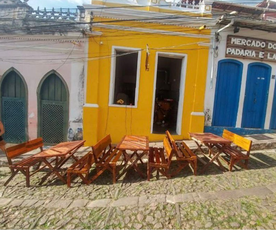 Mesas e cadeiras na fachada de imóvel comercial e residencial localizado no centro histórico de Lençois Chapada Diamantina