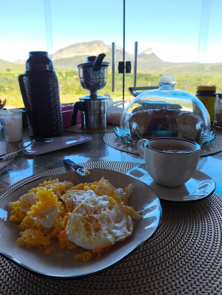 Café da manhã com vista para a serra dos Três Morros, em varanda fechada com vidro em casa para locação temporária em Piatã, Chapada Diamantina, Bahia