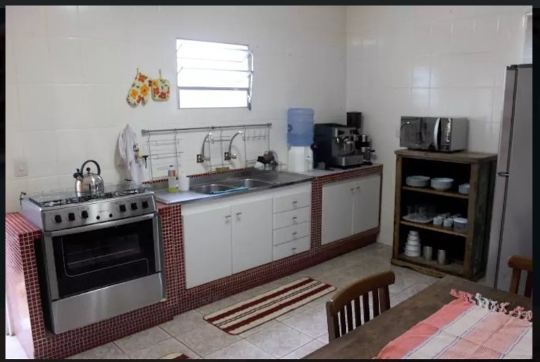 Cozinha mobiliada com fogão 6 bocas e geladeira de inox de casa em centro histórico de Lençóis, na Chapada Diamantina, Bahia