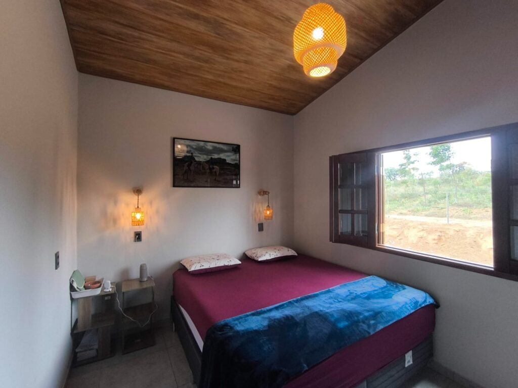 Cama de casal em quarto de casa com acabamento fino para locação temporária em Piatã, Chapada Diamantina, Bahia