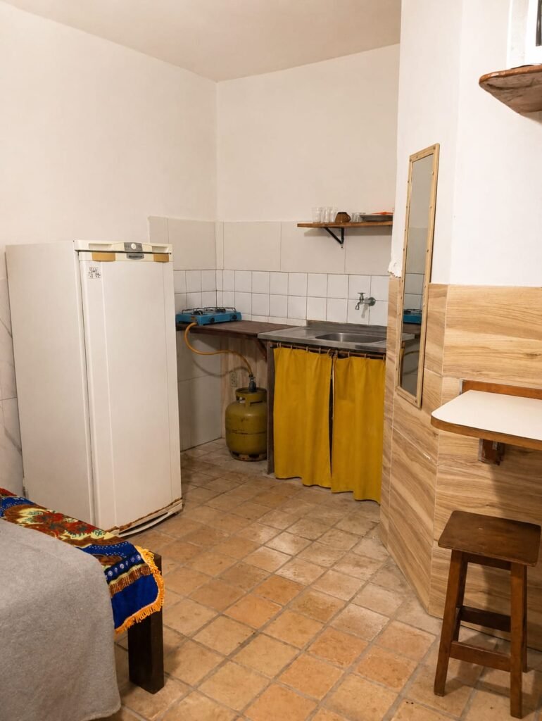 Quarto e cozinha mobiliados do Residencial do Beco, localizado em Lençóis, na Chapada Diamantina, Bahia