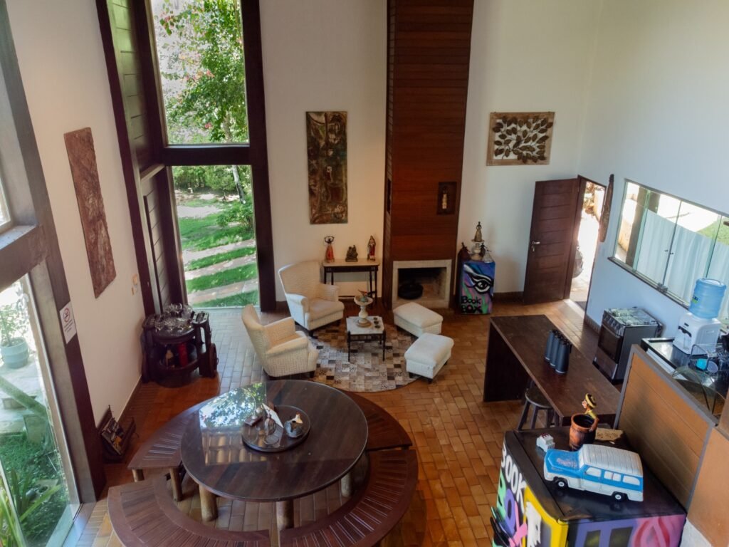 Sala e cozinha mobiliadas com móveis em madeira maciça, fogão e geladeira em inox e decoração charmosa de casa de luxo localizada em Lençóis na Chapada Diamantina, Bahia